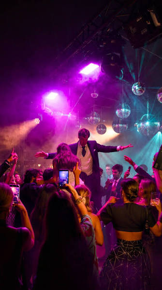 Celebración con música, luces y asistentes bailando