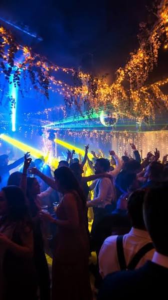 Público disfrutando de una fiesta con iluminación de colores